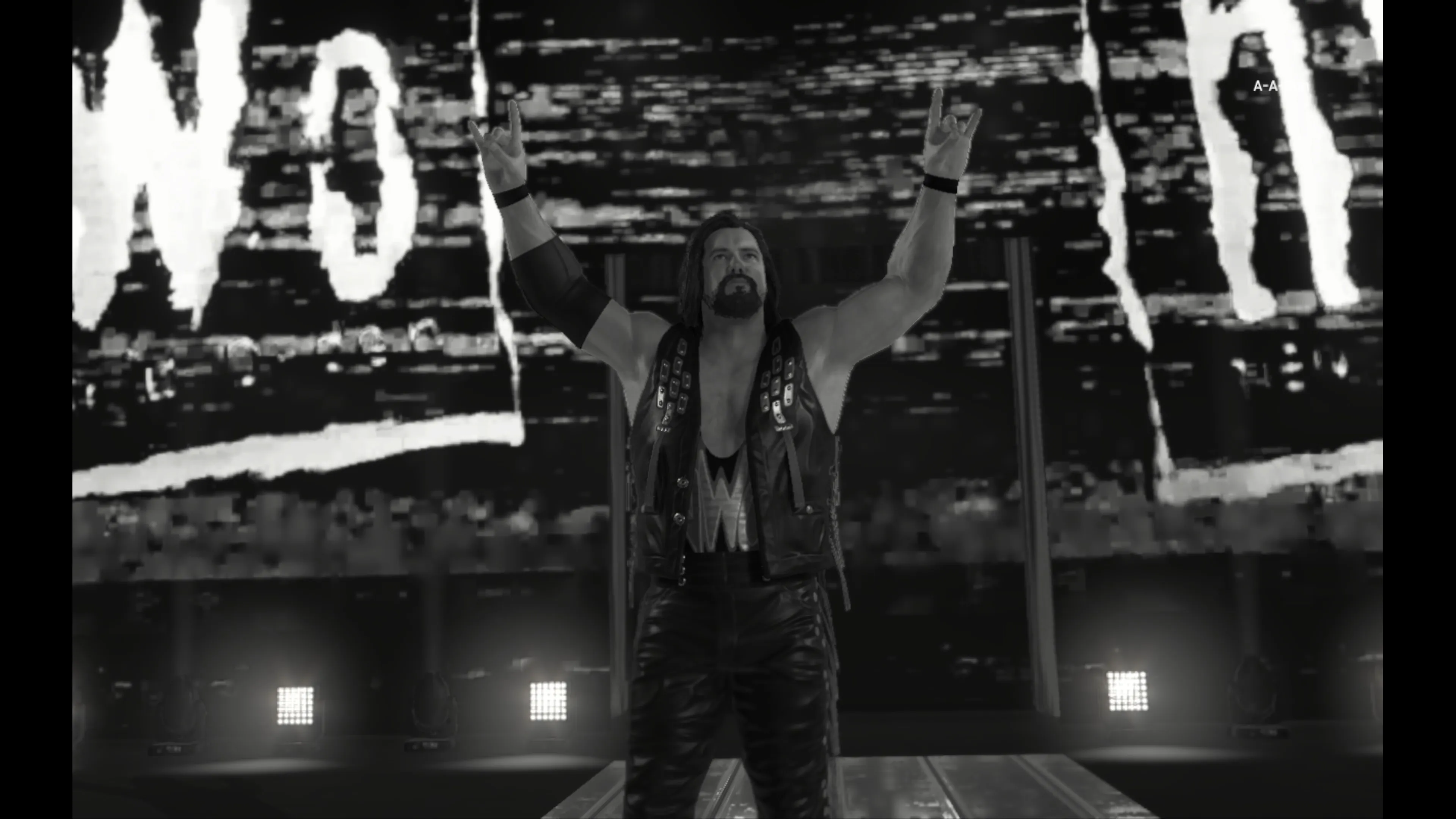 A wrestler in a sleeveless vest with long hair stands on the entrance ramp with both arms raised making hand gestures, surrounded by pyrotechnic effects and large screens displaying nWo graphics in black and white in WWE 2K25